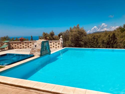 a swimming pool with blue water in a backyard at Green Park Hotel & Residence in Bagnara Calabra