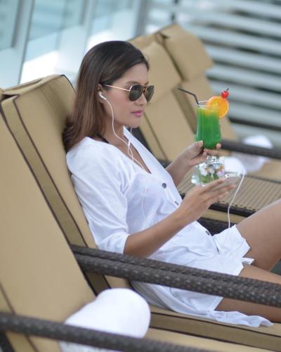 a woman sitting in a chair with a drink at Lex Hotel Cebu in Cebu City