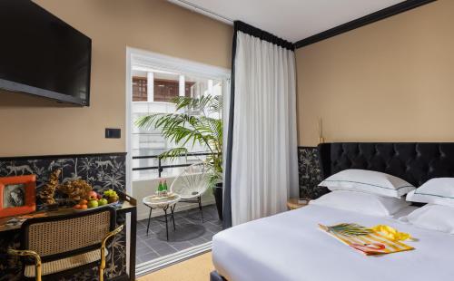 ein Hotelzimmer mit einem Bett und einem Balkon in der Unterkunft Brown Golden House, a member of Brown Hotels in Tel Aviv