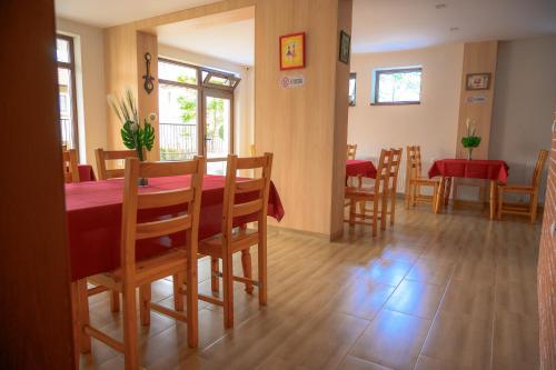 a dining room with a red table and chairs at Вила Влахов in Sapareva Banya