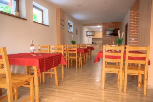 a restaurant with wooden tables and chairs with a red table cloth at Вила Влахов in Sapareva Banya