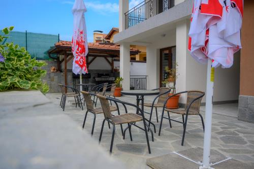 a patio with a table and chairs and an umbrella at Вила Влахов in Sapareva Banya