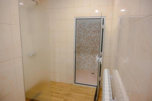 a shower with a glass door in a bathroom at Вила Влахов in Sapareva Banya