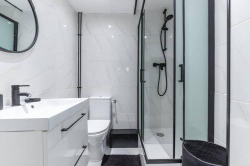 y baño con ducha, aseo y lavamanos. en HSH Volney-Opéra Appartement Design 4P-1BR, en París