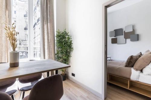 comedor con espejo y mesa en HSH Volney-Opéra Appartement Design 4P-1BR, en París