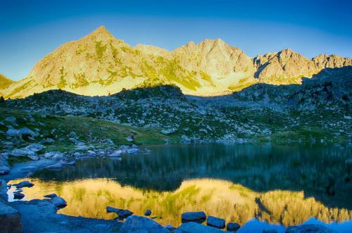 a mountain reflection in a lake with mountains in the background at Hotel Terranova in Pas de la Casa