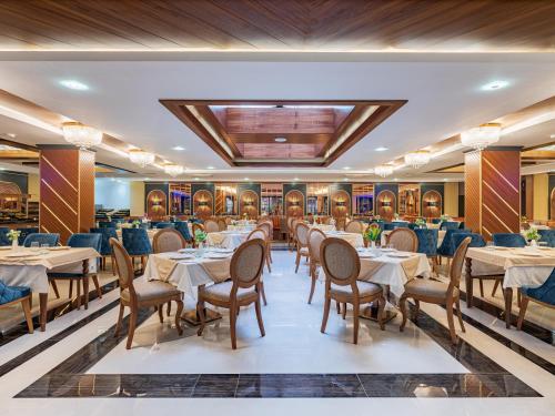 a restaurant with tables and chairs in a room at Elysium Green Suites in Antalya