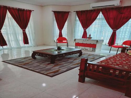 a living room with red curtains and a coffee table at Bukit Baru Homestay in Melaka