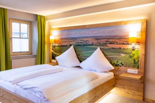 a bedroom with a bed with a painting on the wall at Gasthaus Winzerstube & Hotel in Rödelsee