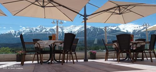 a table and chairs with mountains in the background at Aktiv-Hotel Traube am Mieminger Sonnenplateau in Wildermieming