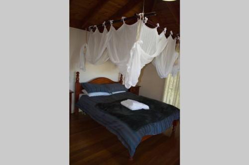 Karinya "Peaceful Home" في Bandon Grove: غرفة نوم بسرير مع مظلة