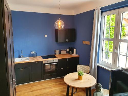 une cuisine avec une table et un mur bleu dans l'établissement Apartment 24, à Cobourg