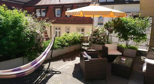 a patio with a hammock and an umbrella at Babelfish Hostel in Würzburg