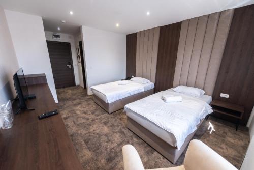 a hotel room with two beds and a television at Hotel Stari Krovovi in Novi Sad