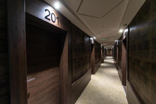 a hallway with wooden walls and a number on the wall at Hotel Stari Krovovi in Novi Sad