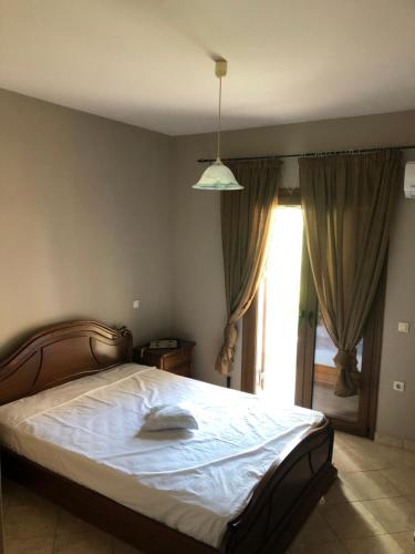 a bedroom with a bed and a large window at 1 Bed Flat - Sleeps 4 - Garden - Parking - Wifi in Mouzákion