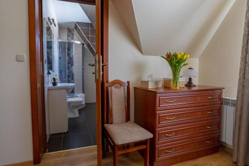 a bathroom with a dresser and a toilet and a chair at Gościniec Polana Błociska-Na Błociskach in Małe Ciche