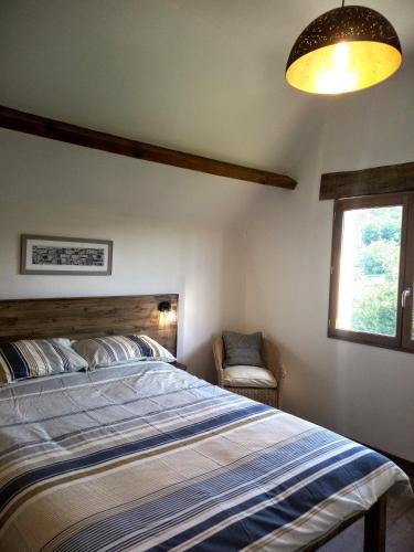 une chambre avec un grand lit et une fenêtre dans l'établissement AU SOLEIL COUCHANT, à Saint-Julien-de-Lampon