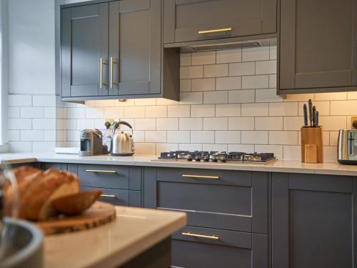 a kitchen with blue cabinets and a counter top at Upper Sheriff's Place in Windermere