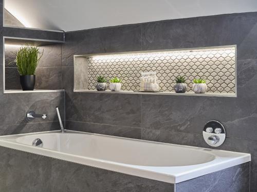 a bath tub in a bathroom with potted plants at Upper Sheriff's Place in Windermere