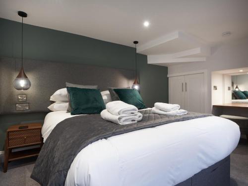 1 dormitorio con 1 cama grande y toallas. en Lower Sheriff's Place en Windermere
