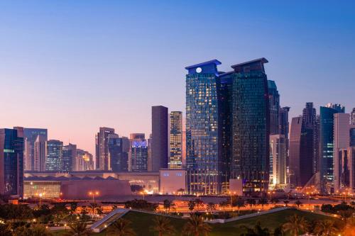 eine Skyline der Stadt in der Nacht mit hohen Gebäuden in der Unterkunft City Centre Rotana Doha in Doha