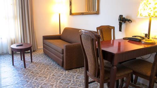 a living room with a couch and a table and a room with a desk at Jerusalem Gold Hotel in Jerusalem