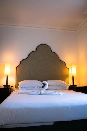 a large bed with a large headboard and two lamps at Jerusalem Gold Hotel in Jerusalem