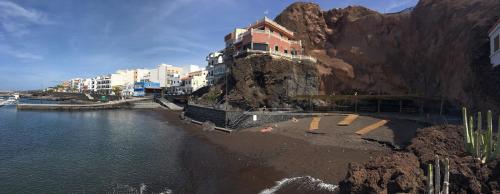 a building on the side of a mountain next to the water at LAS CALMAS in La Restinga