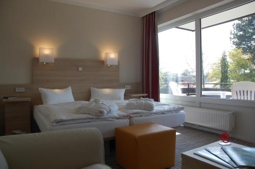 a hotel room with a bed and a large window at Parkhotel Bad Bevensen ,ThermePlus in Bad Bevensen
