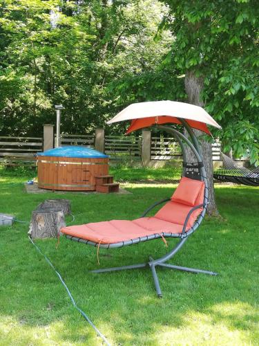 a hammock with an umbrella sitting in the grass at Ubytovanie Queen in Nováky