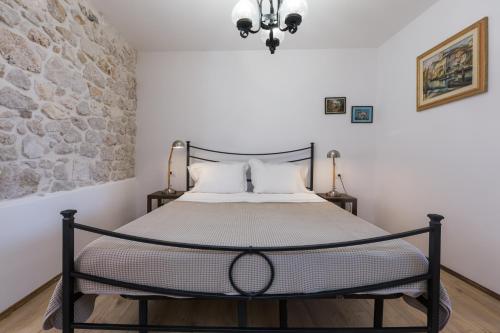 sypialnia z łóżkiem z kamienną ścianą w obiekcie Apartment Lanterna Veneziana w Rovinj