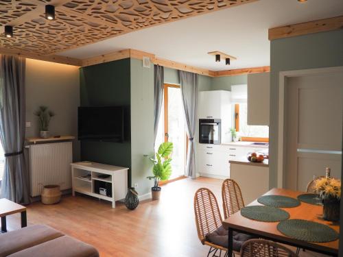 a kitchen and living room with a table and chairs at Apartament MONTANA in Karpacz