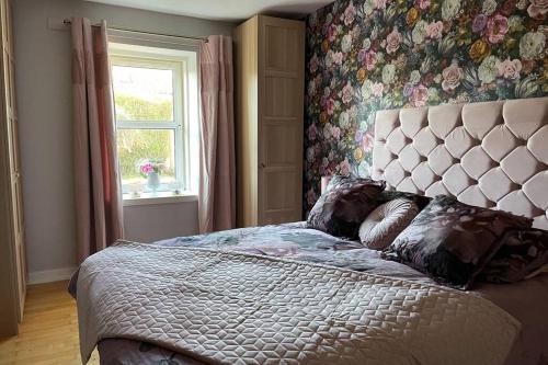 a bedroom with a large bed and a window at Castle View House in Dalkeith