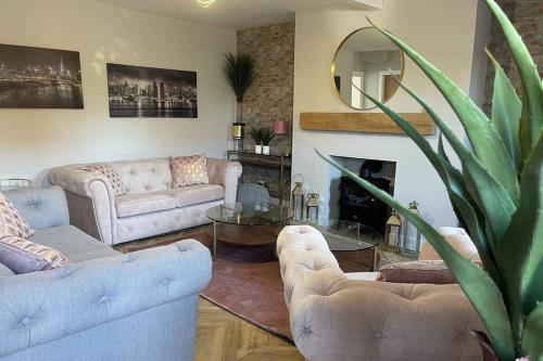 a living room with two couches and a fireplace at Castle View House in Dalkeith