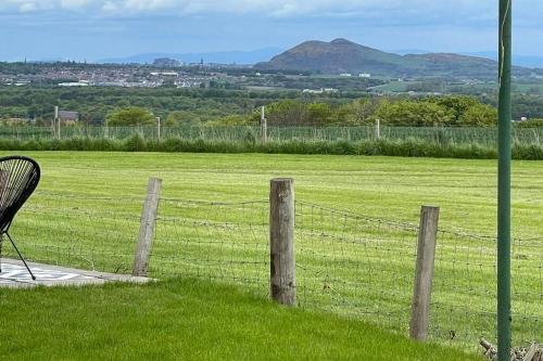 a fence in front of a field with a chair at Castle View House in Dalkeith