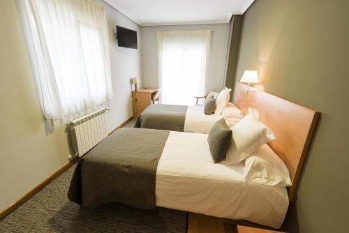 Un pat sau paturi într-o cameră la Hotel Porto do Barqueiro
