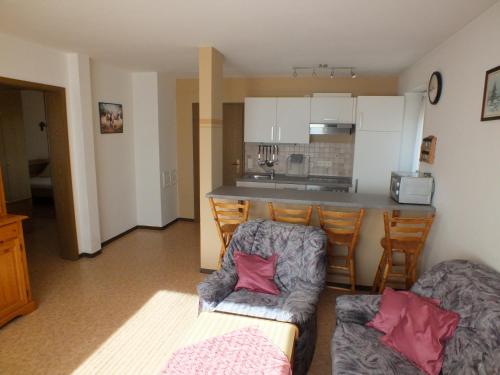 ein Wohnzimmer mit einem Sofa und einer Küche in der Unterkunft Pension & Reitschule Fuchsenhof in Seebarn