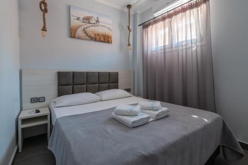 a bedroom with a bed with two towels on it at Athena's Studios in Polykhrono