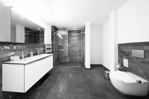 a bathroom with a toilet and a sink and a shower at Swiss Hotel Apartments - Interlaken in Interlaken