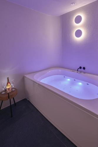 a white bath tub in a room with a table at Triangel Boutique Hotel in Kranjska Gora