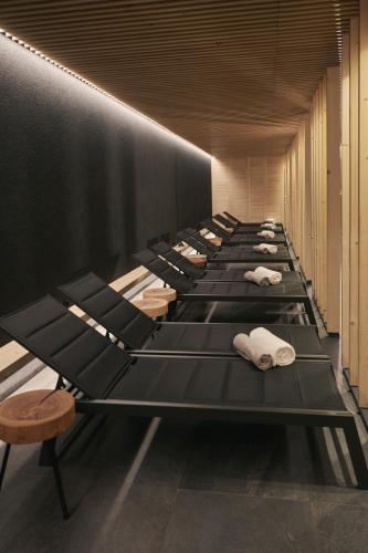 a row of black beds in a room at Triangel Boutique Hotel in Kranjska Gora