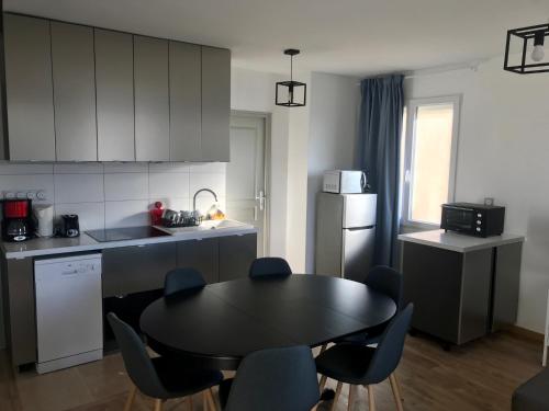 eine Küche mit einem Tisch und Stühlen in einer Küche in der Unterkunft Appartement La Guignette in La Rochelle