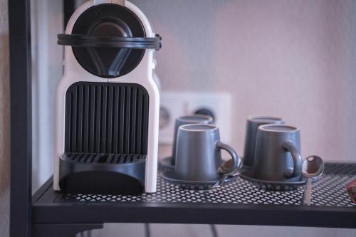 Una cafetera en un estante con tazas. en Hotel Vondel Garden - Digital Access, en Ámsterdam