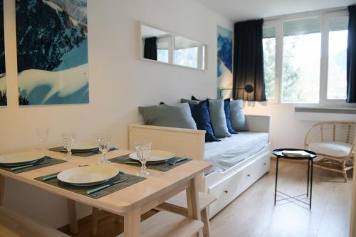 - un salon avec un lit et une table avec des verres dans l'établissement Appartement Cosy - Aiguille du Midi, à Chamonix-Mont-Blanc