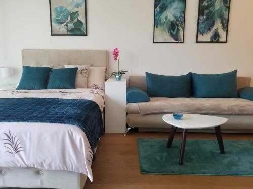 um quarto com uma cama, um sofá e uma mesa em Azura Residence - new luxury apartment em Belgrado