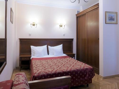 a bedroom with a bed with a wooden headboard at Apartamenty Furta Dominikańska in Sandomierz
