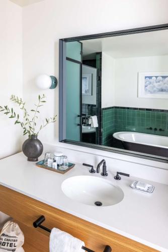a bathroom with a sink and a large mirror at El Capitan Hotel in Merced