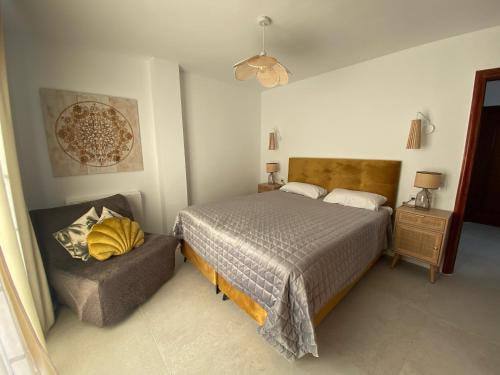 a bedroom with a bed and a chair in it at Tres Terrazas Ocean view apartment in Adeje