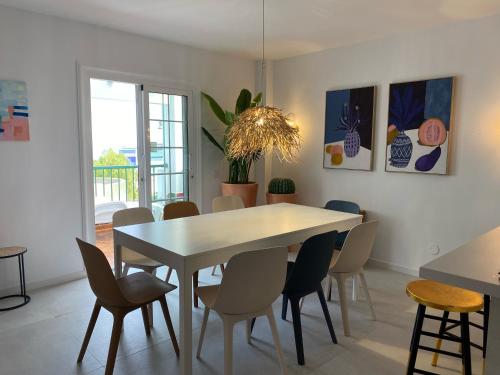 a dining room with a white table and chairs at Tres Terrazas Ocean view apartment in Adeje
